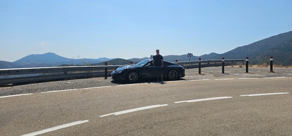 Ignacio Milán with a black Porsche on a mountain road
