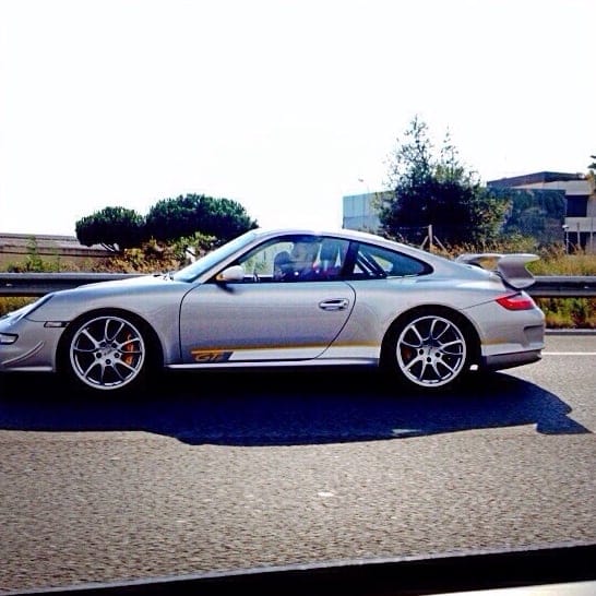 Silver Porsche 911 GT3 997 in profile, with rear wing and roll cage