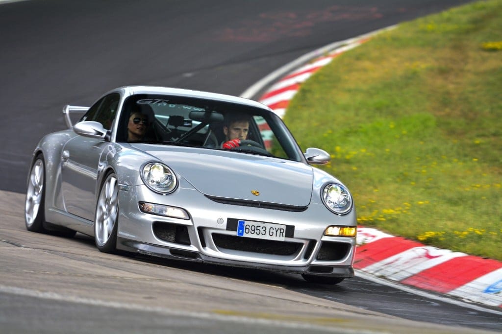 Silver Porsche 911 GT3 cornering on track, with Ignacio Milán at the wheel