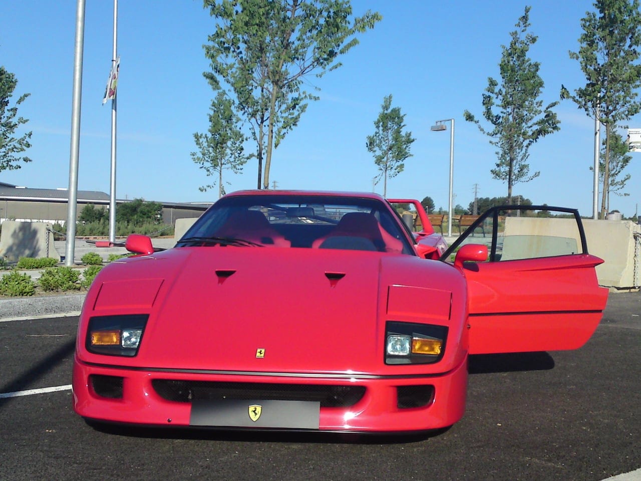 Head-on view of a red Ferrari F40 with the door open