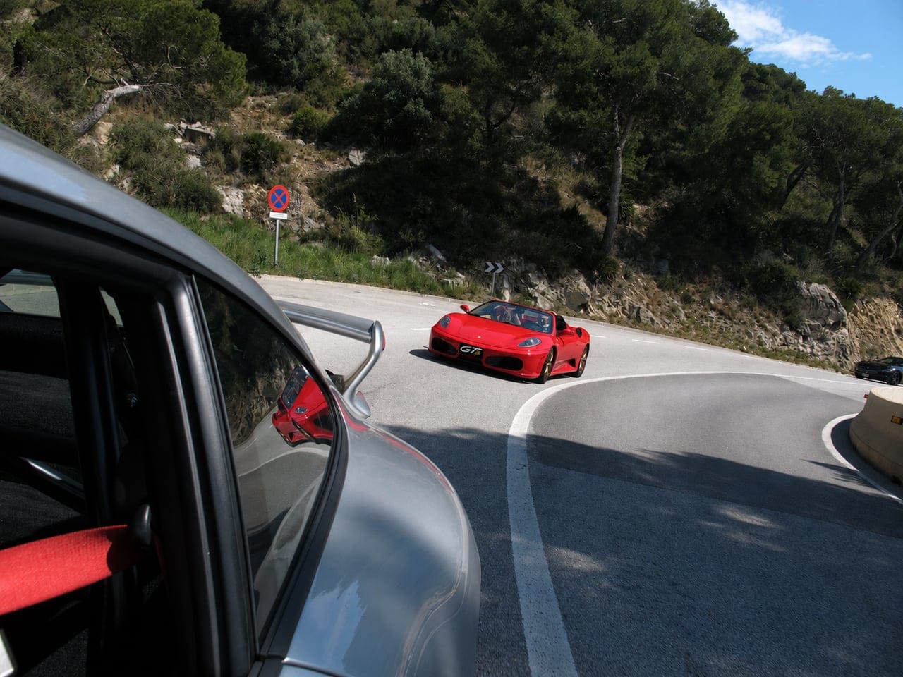 Red Ferrari F430 Spider on a mountain road during a GTlife route